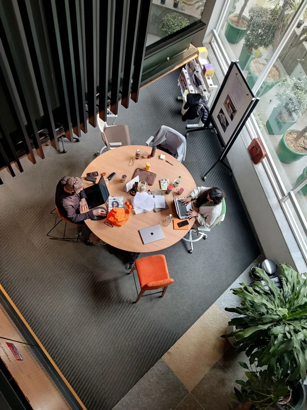 Two professionals using laptops at a meeting table in Gurugram, India
