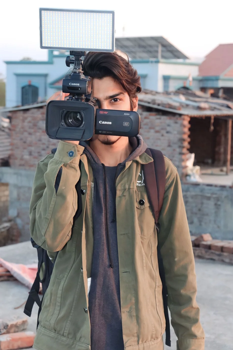 A reporter holding a video camera on location in Mahuva, India