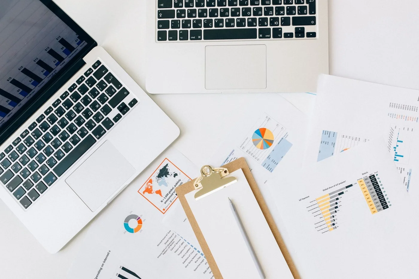 Laptops, charts and planning documents arranged on a work table