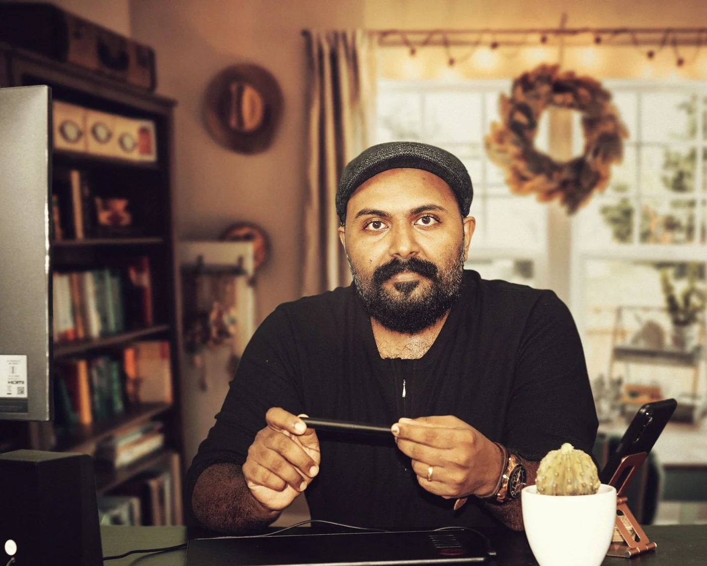 An Indian professional holding a pen at his workspace
